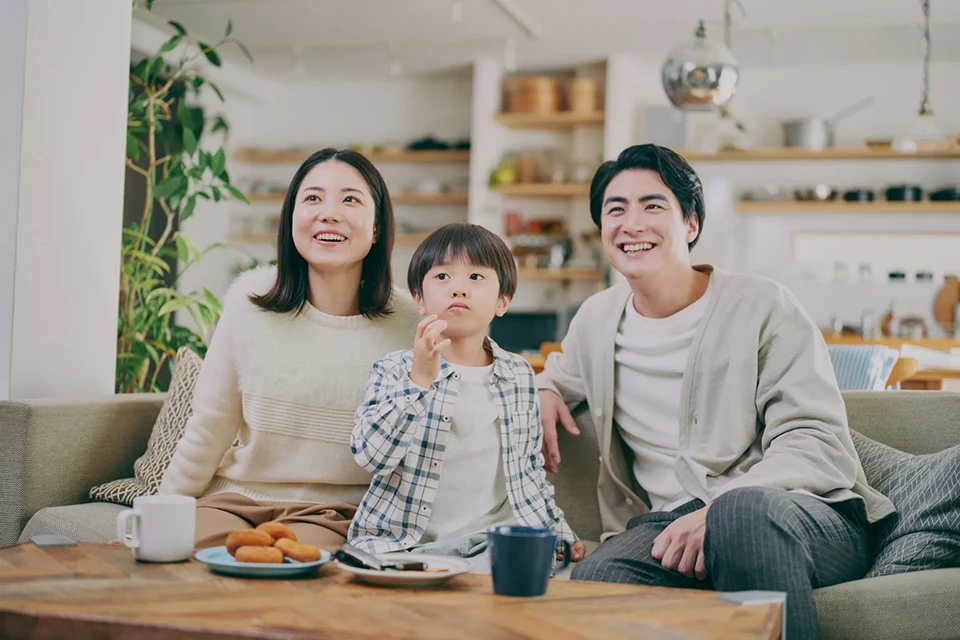ソファでテレビを楽しむ家族